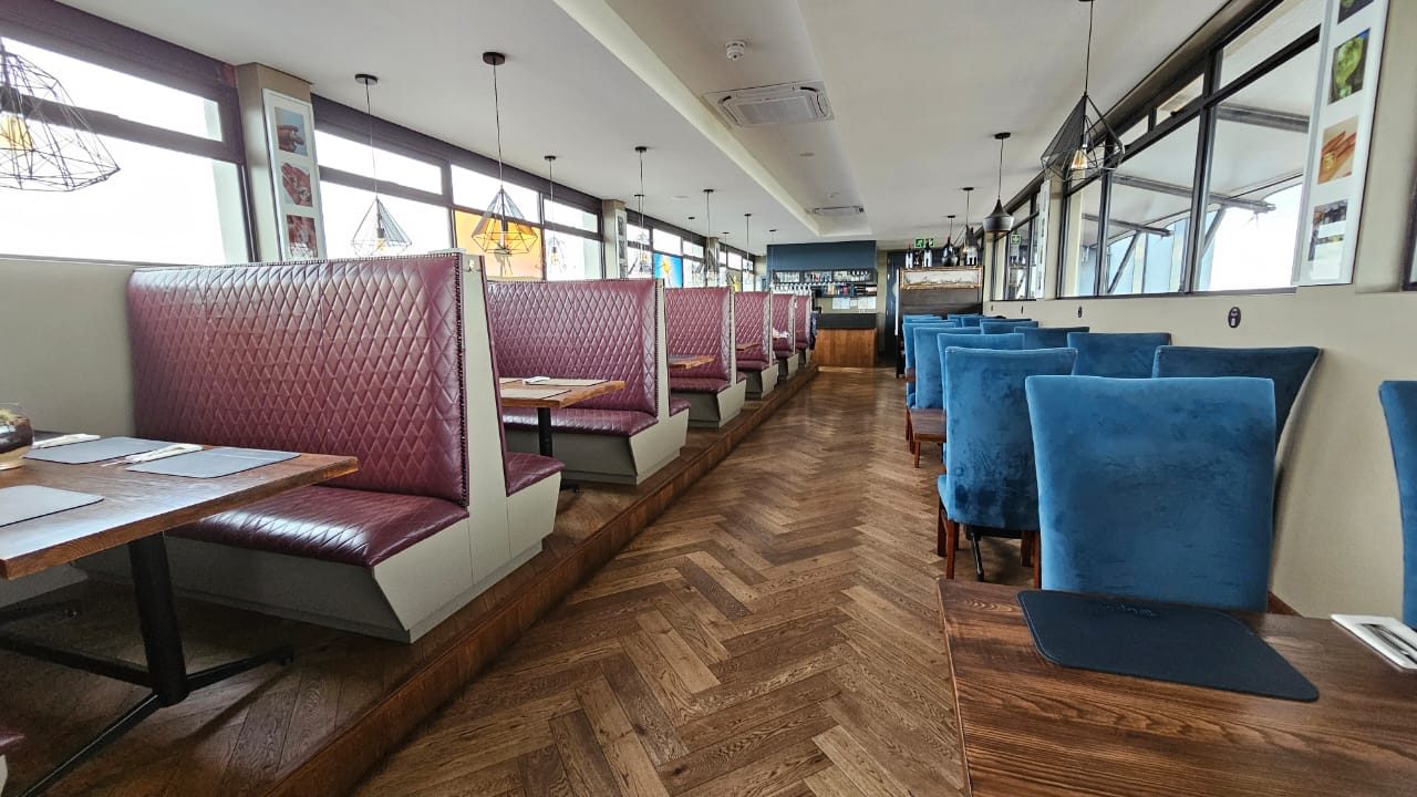 Restaurant with quilted booths and blue velvet chairs