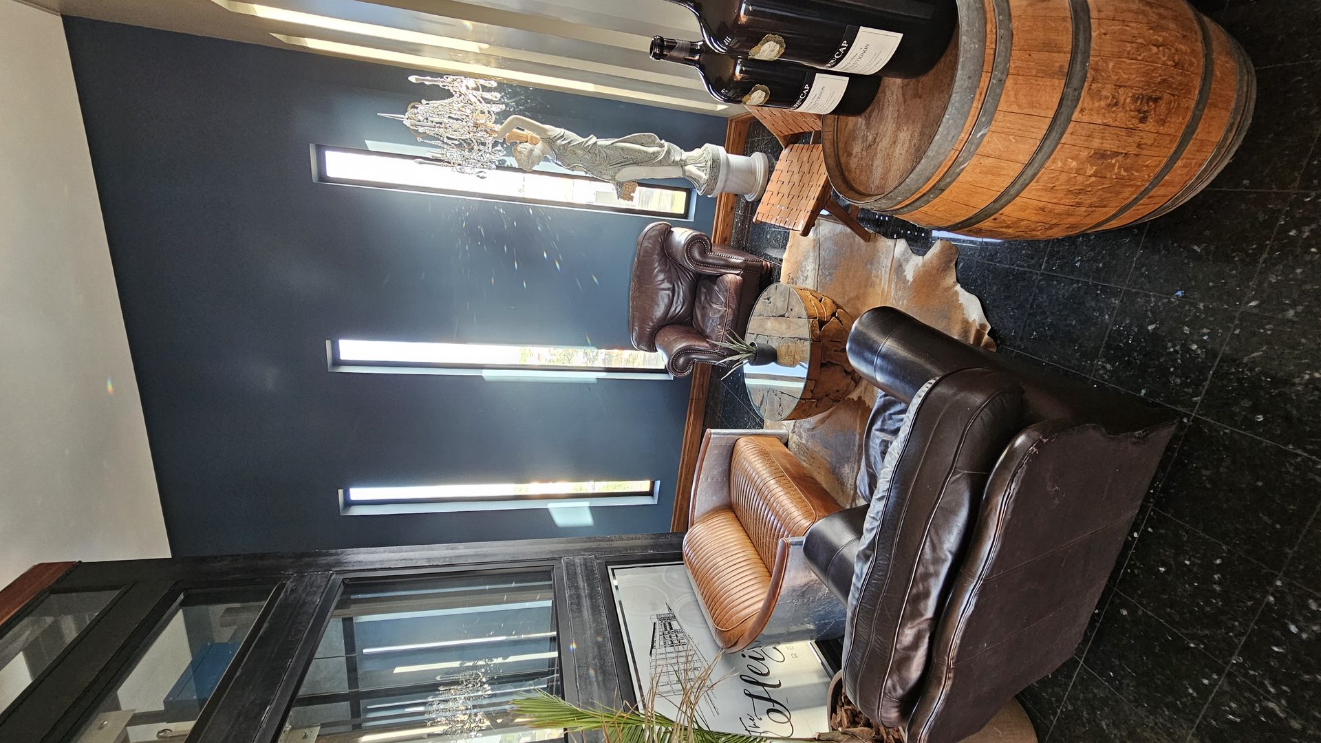 Lounge entrance with leather wing-back chairs and a wine barrel